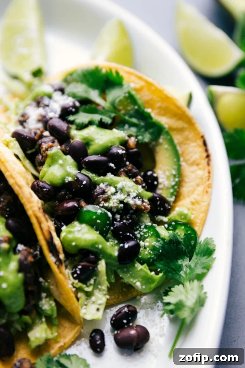 Savory Black Bean Tacos generously topped with homemade sauce, crumbled Cotija cheese, and fresh cilantro, ready for enjoyment.
