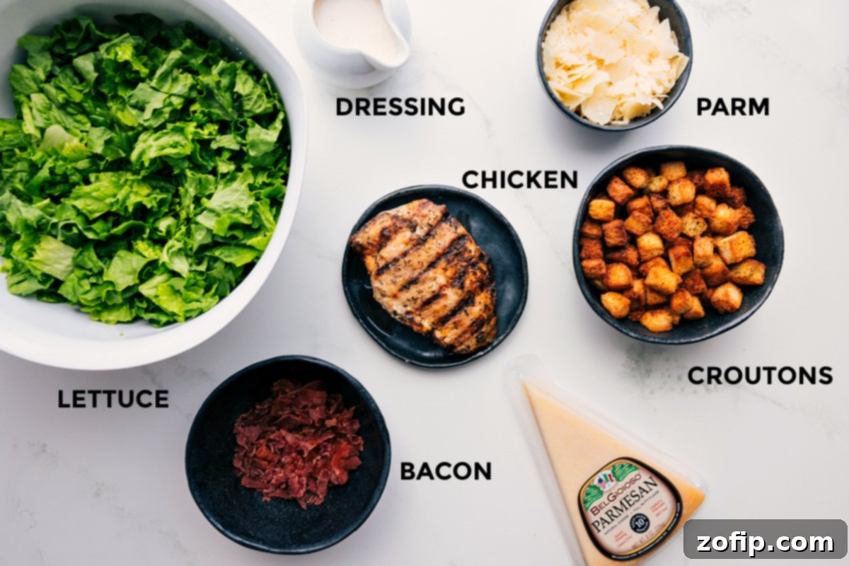 Ingredients laid out for Caesar Salad Pizza, including naan bread, chopped romaine lettuce, grilled chicken, mozzarella cheese, and parmesan.