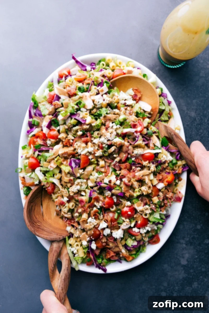 A vibrant bowl of Portillo's Chopped Salad with two serving spoons, ready to be enjoyed.