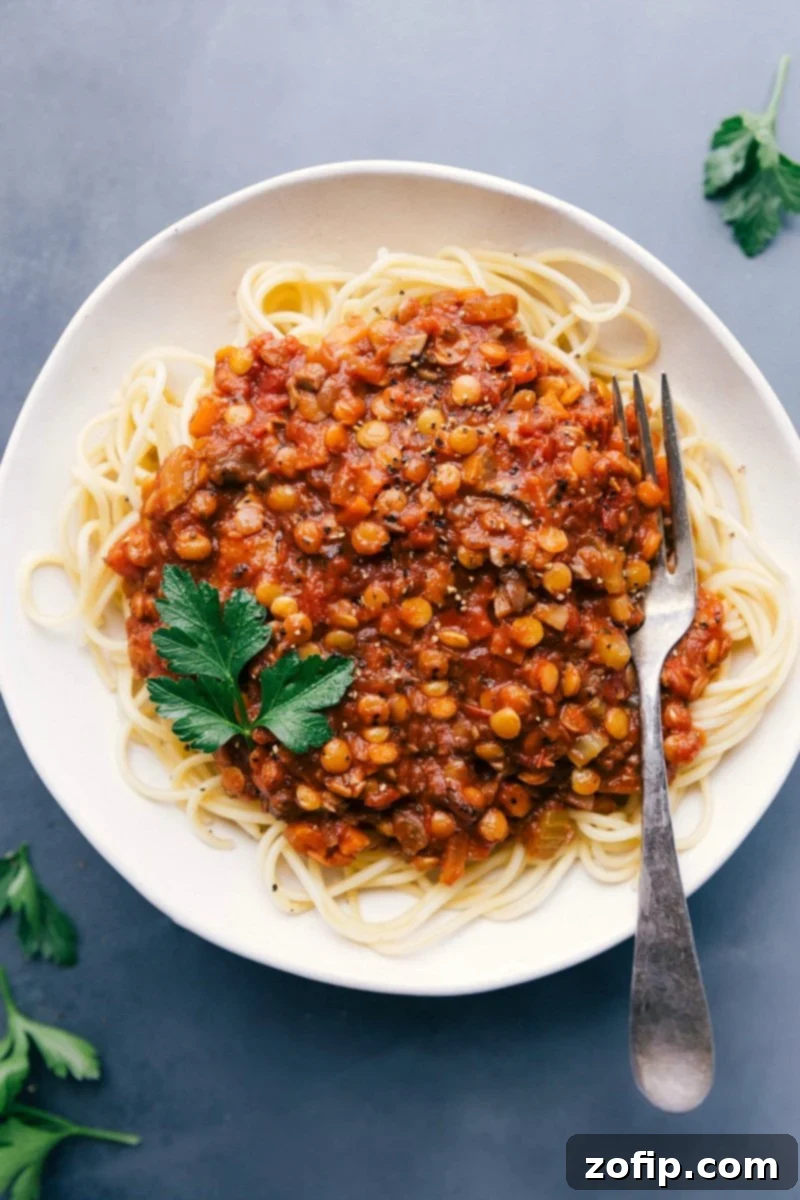 Lentil bolognese served over spaghetti, presenting a savory and mouth-watering meal.