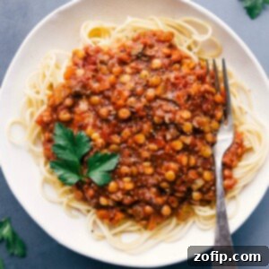 Lentil bolognese served over spaghetti, presenting a savory and mouth-watering meal.