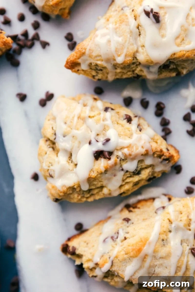 Homemade Chocolate Chip Scones 2 Chocolate chip scones with a luscious glaze and scattered chocolate chips, ready to be devoured.