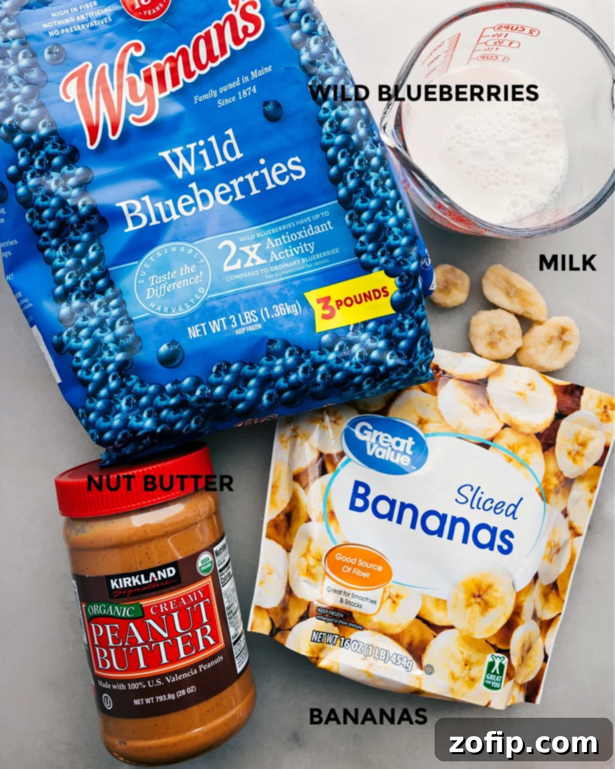 The four ingredients: frozen fruit, banana, almond milk, and nut butter prepped out for easy assembly.