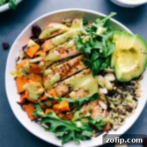 Chicken and wild rice in a bowl, featuring well-cooked, sliced chicken and creamy sauce poured on top, creating a healthy and delicious meal.