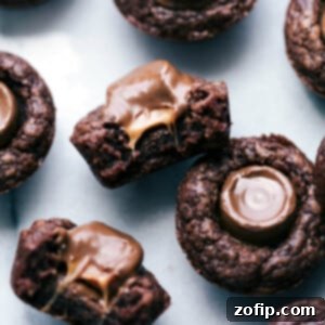 A close-up of mini brownie bites with Rolos, one cut in half to expose the gooey, melty insides.