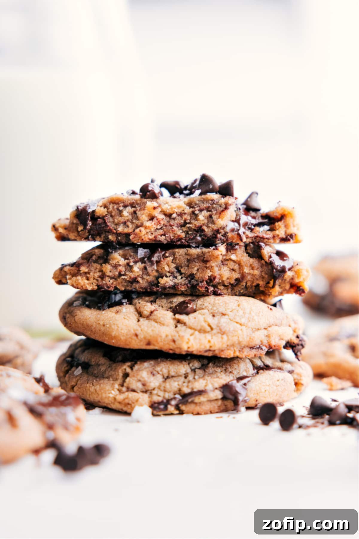 Stacked Small Batch Chocolate Chip Cookies, one broken open to reveal its soft, gooey, melted chocolate center.
