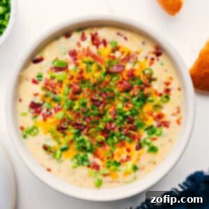 Delicious Loaded Potato Soup in a rustic bowl, garnished with chives and bacon.