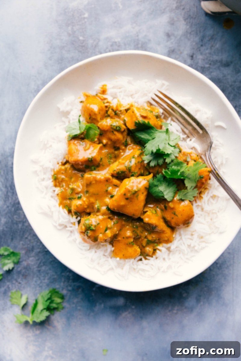 Overhead image of Chicken Curry over rice in a bowl, with a fork on the side. A perfect easy weeknight meal ready in 30 minutes.