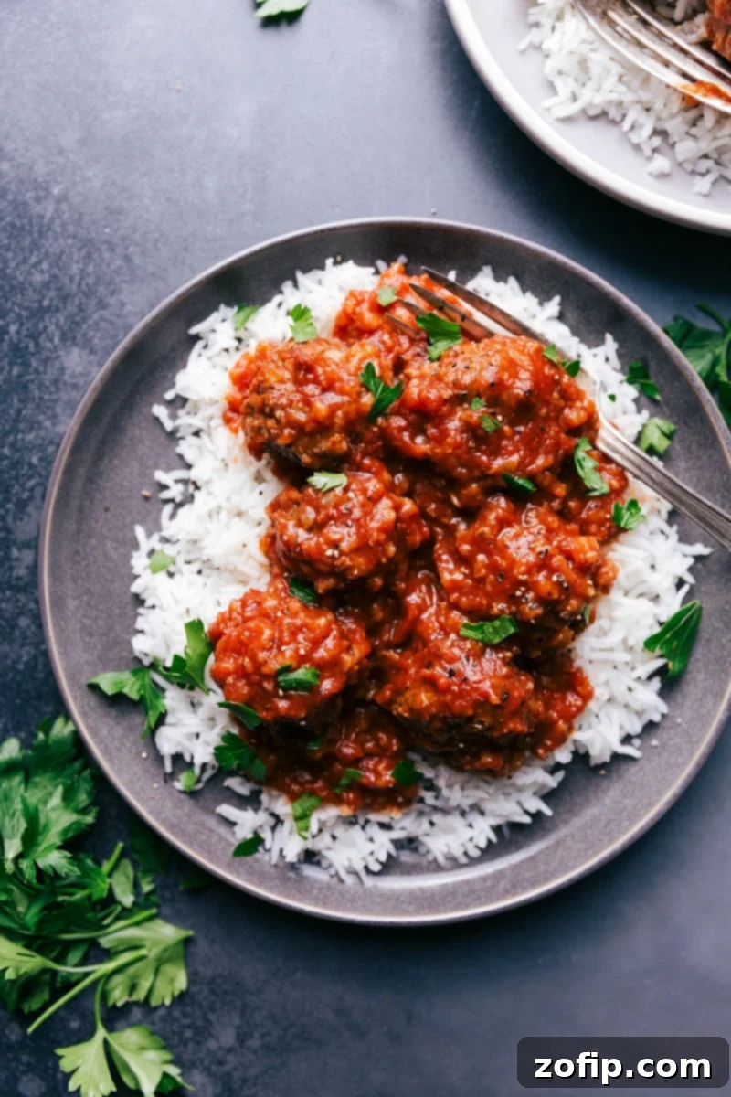 Porcupine meatballs served over a bed of rice, garnished with fresh herbs.