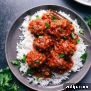Porcupine meatballs served over a bed of rice, garnished with fresh herbs.
