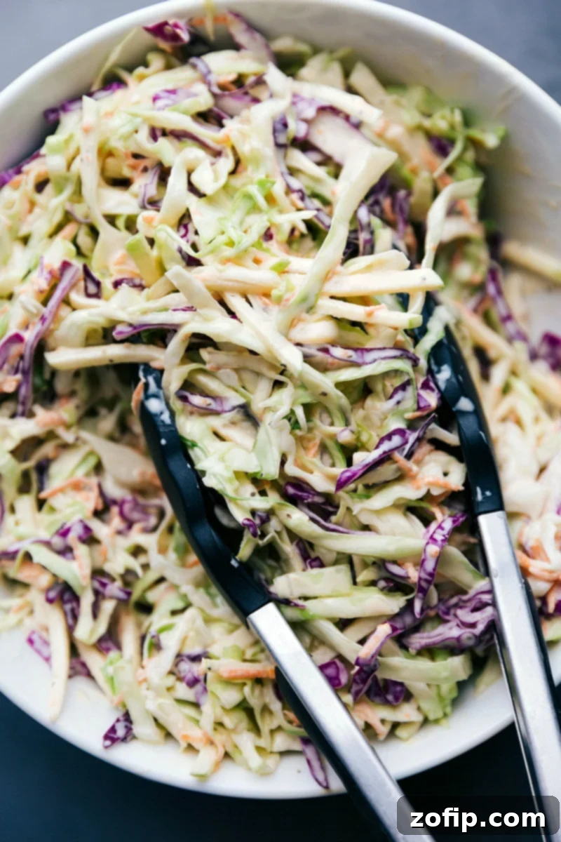 A large serving bowl filled with creamy, vibrant coleslaw, fully dressed and ready to be enjoyed as a refreshing side dish.