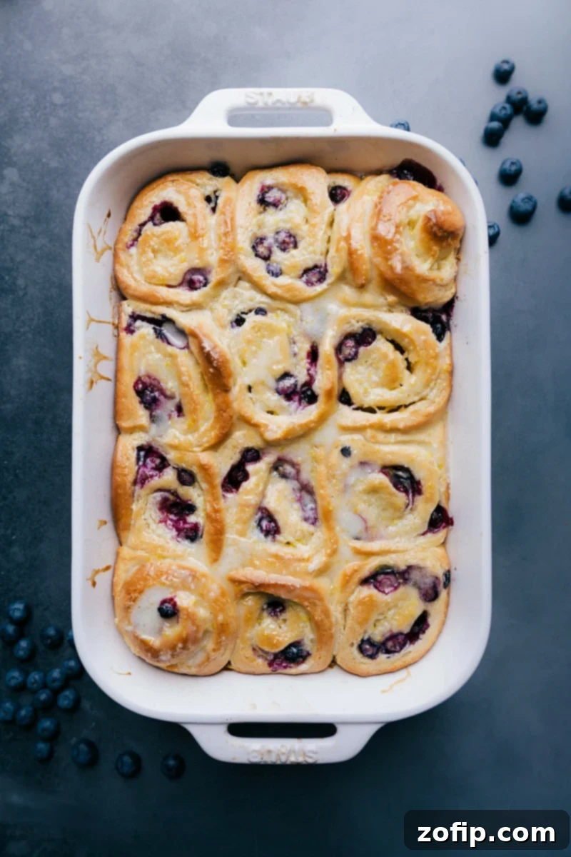 Delicious Lemon-Blueberry Sweet Rolls: Your New Favorite Indulgence Scrumptious lemon-blueberry sweet rolls, glistening with a vibrant lemon glaze and bursting with blueberries, perfectly arranged and ready to be enjoyed.