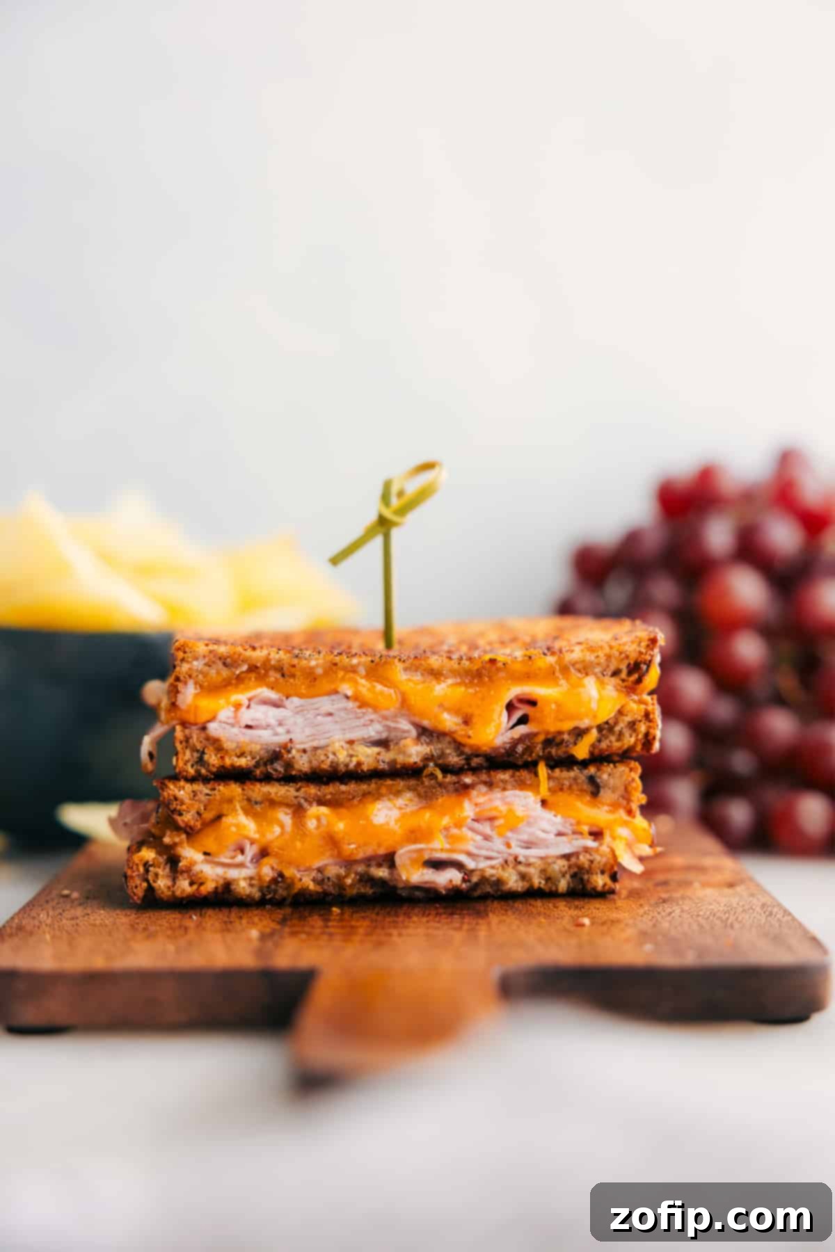 Golden Ham and Cheese Treat 2 A perfectly grilled ham and cheese sandwich, cut in half, revealing the melted cheese and savory ham within crispy bread.