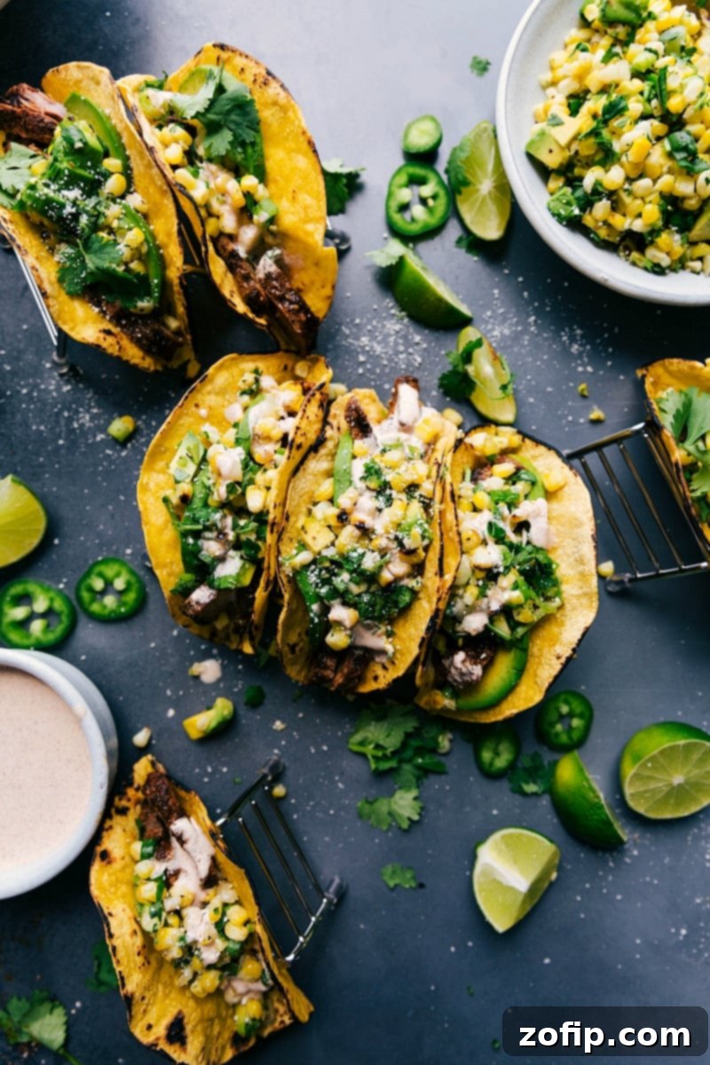 Delicious steak tacos garnished with corn salsa, cheese, and various toppings, prepared and served on a rustic plate.