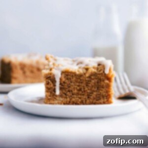 Cinnamon Apple Streusel Coffee Cake 2 A delicious slice of Apple Coffee Cake on a plate, topped with a beautiful drizzle of frosting. This image is perfect for showcasing the finished dessert, ready to be enjoyed.