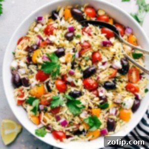 Flavorful Orzo Pasta Salad 3 Delicious and healthy orzo pasta salad in a bowl with spoons, ready to be served.