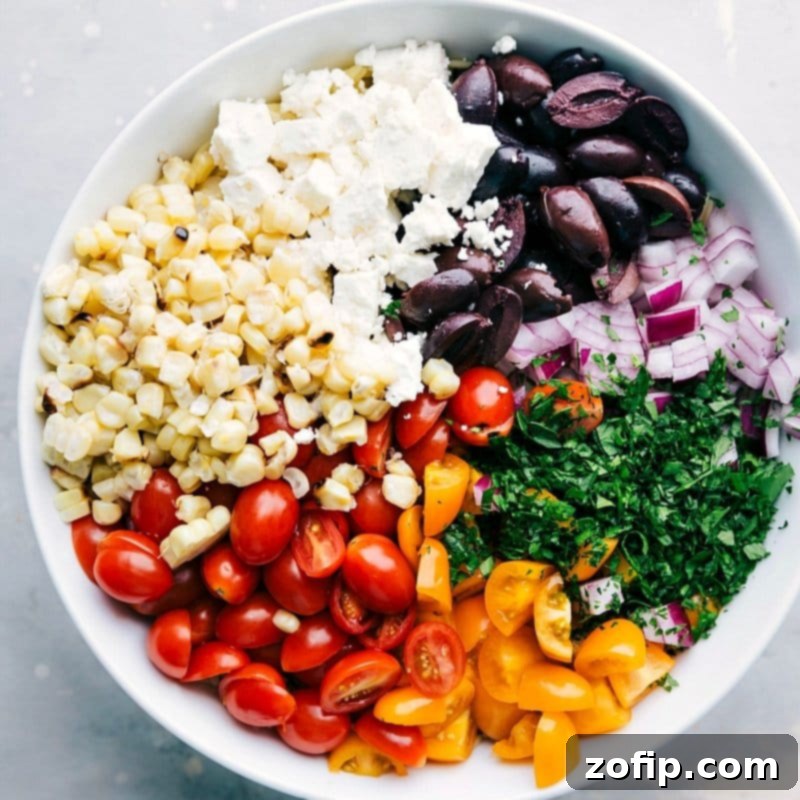Preparing Orzo Pasta Salad: Ingredients Ready to Mix for Flavorful Dish All ingredients in a bowl ready to be mixed together, creating a dish with perfectly complimentary flavors.