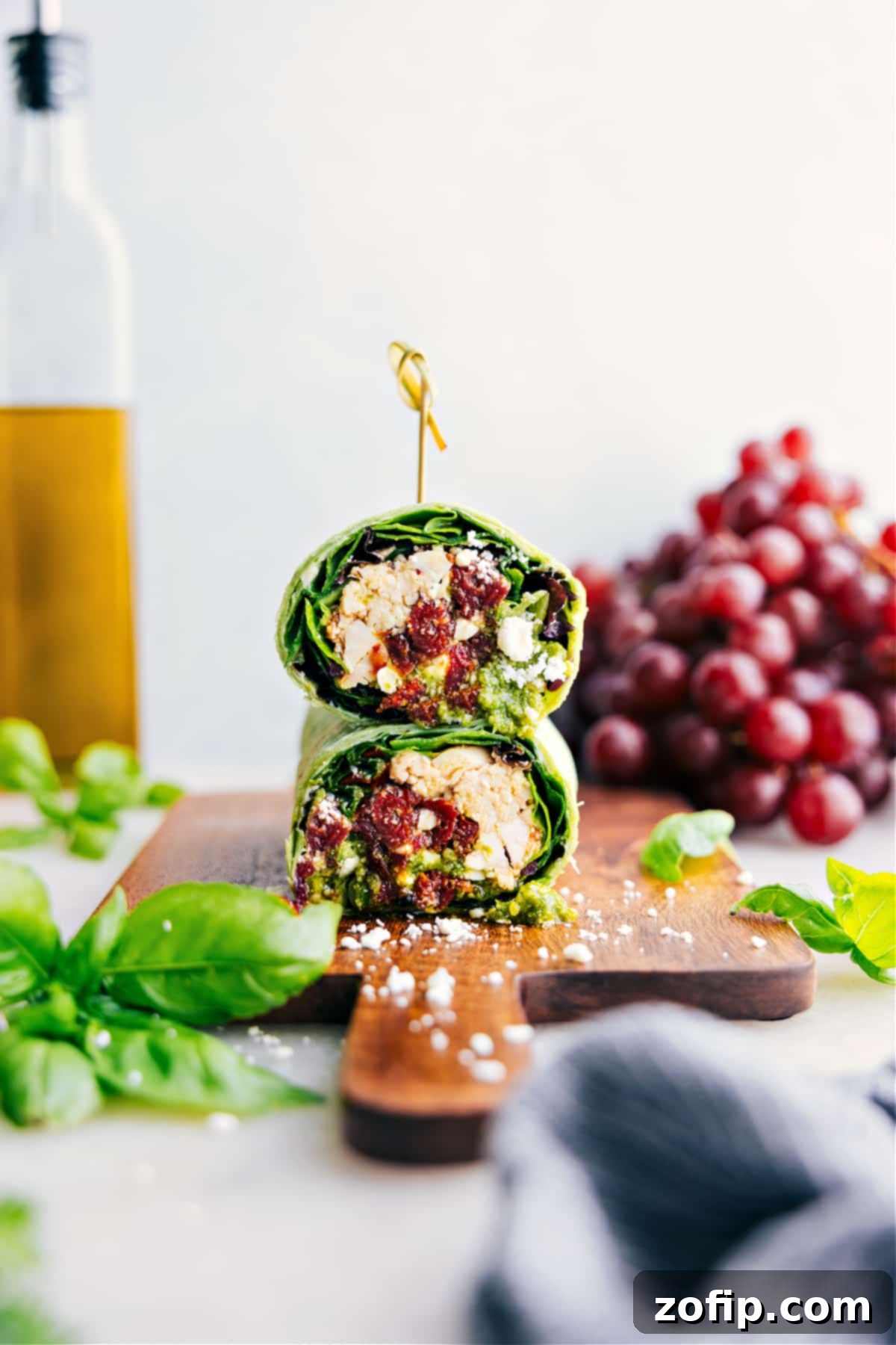 Easy And Delicious Mediterranean Wraps A freshly prepared Mediterranean Wrap, sliced in half, showcasing its healthy and delicious filling, ready to be enjoyed as a quick meal.