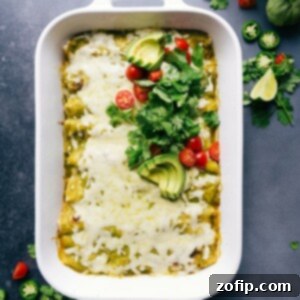 Warm and flavor packed green chile chicken enchiladas in the pan, topped with fresh herbs and tomatoes.