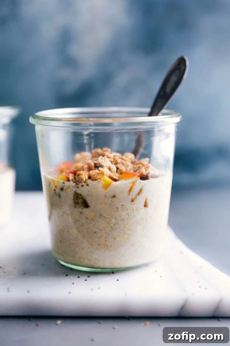 A beautifully presented bowl of Peach Cobbler Overnight Oats, adorned with fresh peach slices and golden, crunchy streusel, ready to be enjoyed as a refreshing and satisfying breakfast.