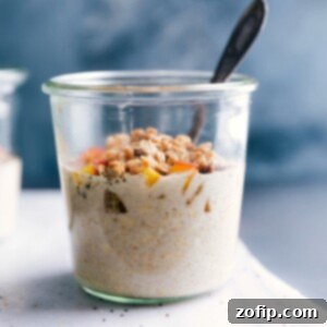 A generous serving of Peach Cobbler Overnight Oats, beautifully topped with fresh peach slices and a golden, crunchy streusel, presented in a bowl ready to be savored.