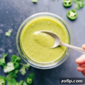 Zesty Tomatillo Enchilada Verde 3 A close-up shot of a bowl of rich, homemade green enchilada sauce, garnished with fresh cilantro.