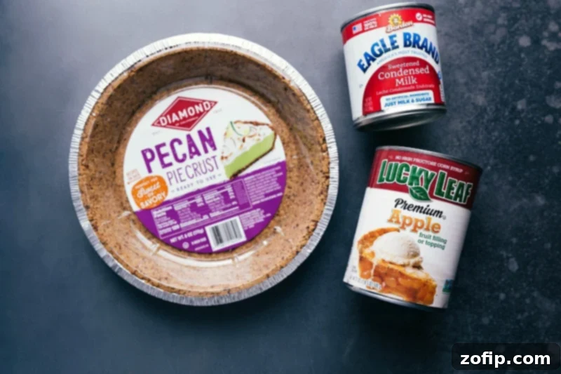 This simple Apple Streusel Pie starts with a pecan crust, creamy apple filling, crunchy streusel topping, and a drizzle over top. Recipe via ChelseasMessyApron #easy #best #homemade #recipe #topping #quick #simple #apple #streusel #pie Image of key ingredients used in this Apple Streusel Pie recipe, including canned apple pie filling and sweetened condensed milk.