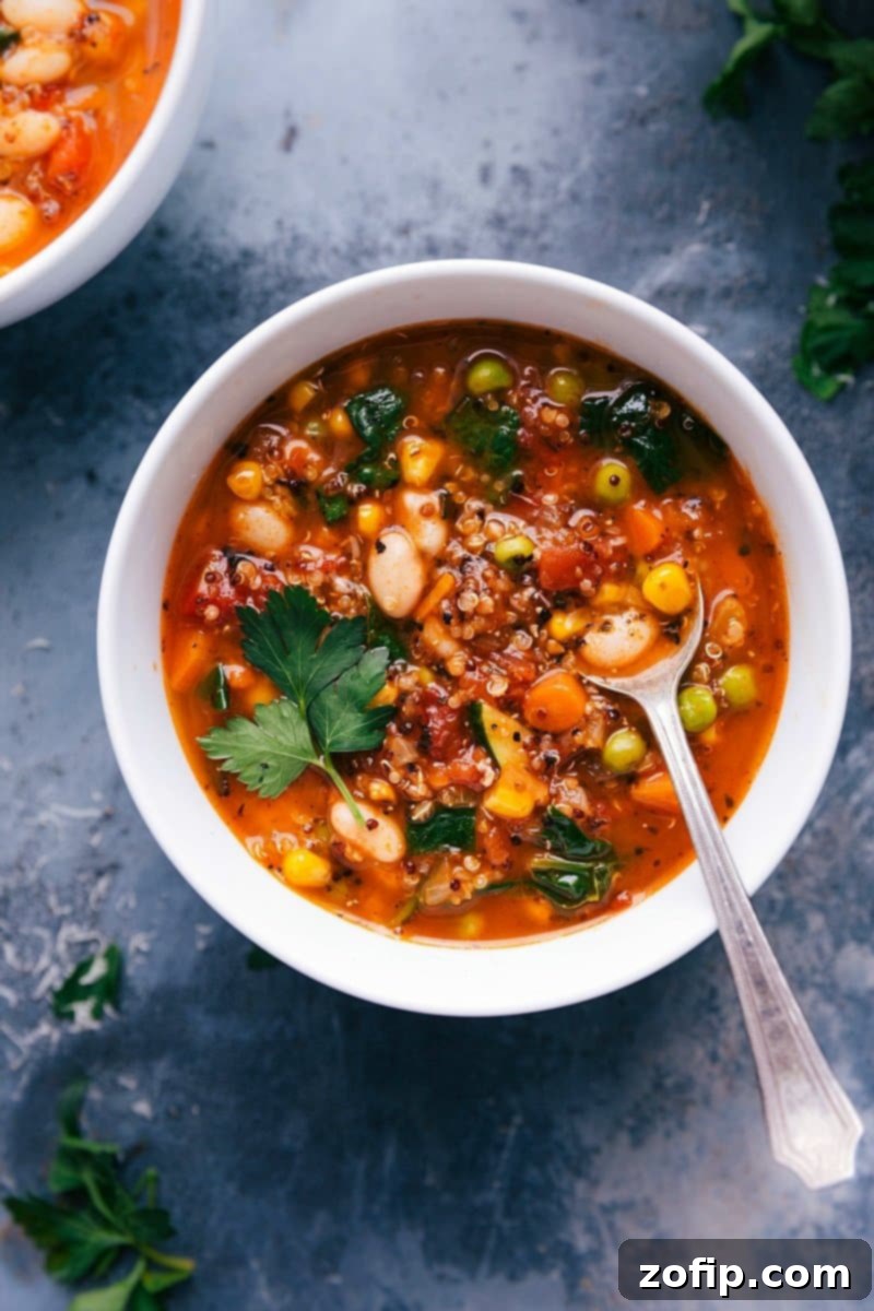 A steaming bowl of healthy minestrone soup, rich with colorful vegetables like carrots, zucchini, spinach, and beans, with a spoon resting in it, ready to be enjoyed.
