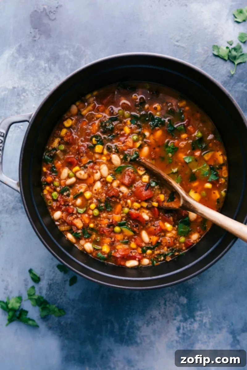 A large, steaming cast-iron pot brimming with hearty, healthy minestrone soup, featuring a rustic wooden spoon dipped into the colorful vegetable and quinoa mixture, ready to be served and enjoyed.