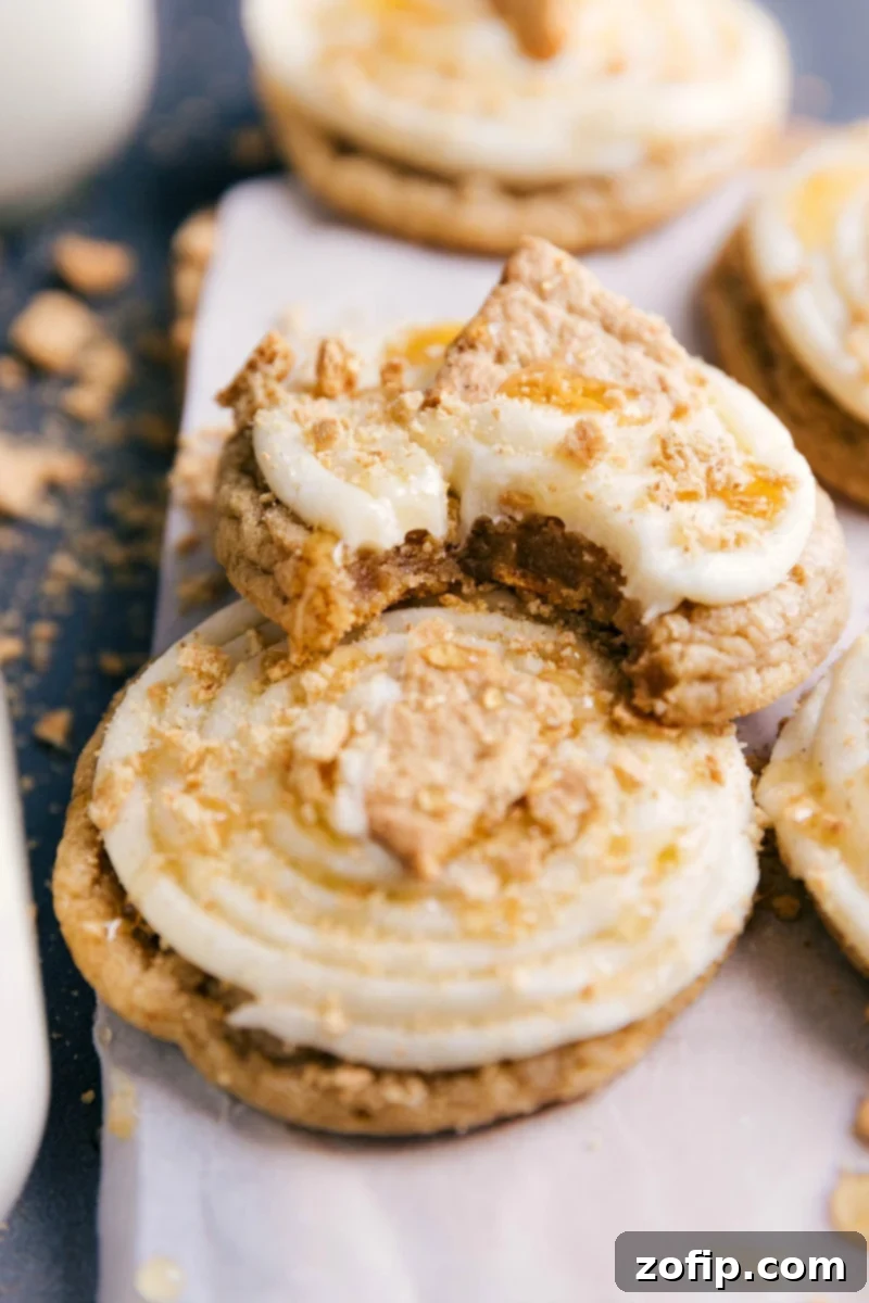 Finished Frosted Graham Cookies with Bite Finished dessert on a plate, one with a bite taken out, revealing the delicious interior.