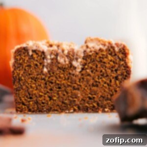 Autumn Spiced Pumpkin Streusel Bread 2 Pumpkin bread with streusel topping, slice removed, showcasing its deliciousness.