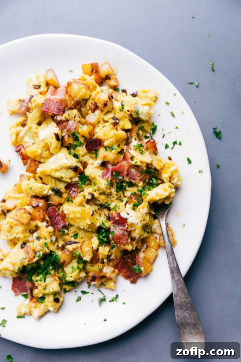 Savory Egg Skillet Garnished with Parsley, Served on a Plate and Ready for Consumption. A freshly prepared egg skillet served on a white plate, garnished with vibrant green chopped parsley, ready for enjoyment.