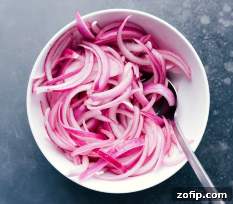 A bowl filled with vibrant purple pickled red onions, ready to be served as a fresh and tangy topping for tacos.