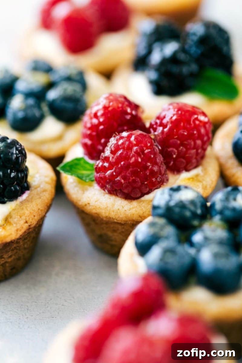 Delightful Mini Fruit Tarts Garnished with Berries and Mint Mini fruit tarts recipe topped with raspberries, blueberries, blackberries, and fresh mint.
