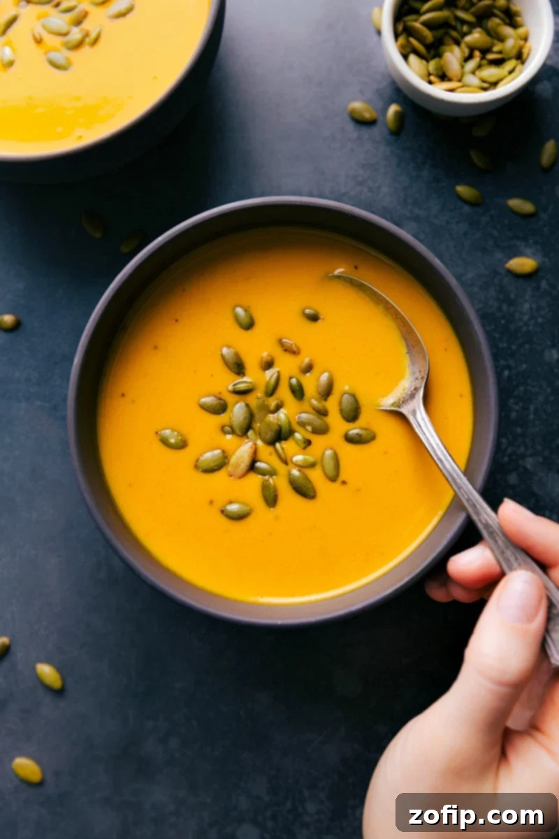 Carrot Soup in a bowl garnished with pepita seeds, a healthy and delicious meal.