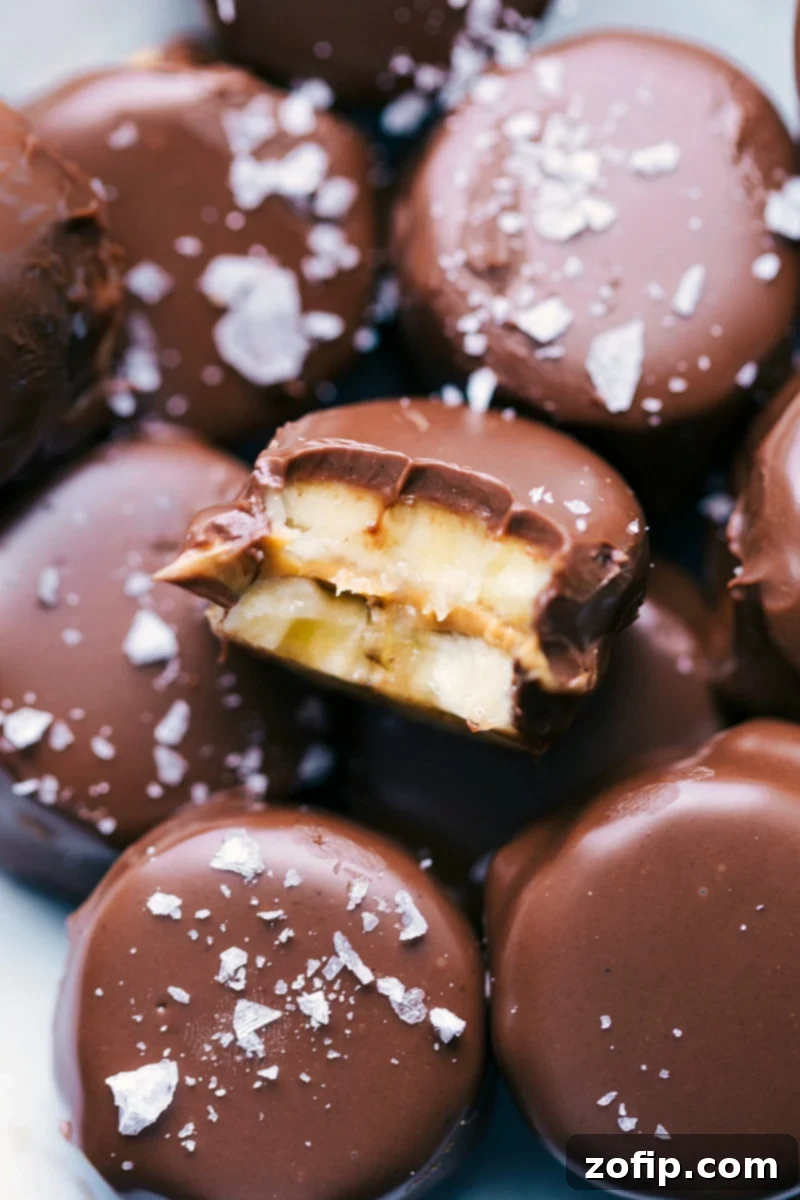 A vibrant pile of Banana Bites, with one featuring a delicious bite taken out, showcasing the creamy filling and chocolate coating. Perfect for a quick, healthy snack or dessert.