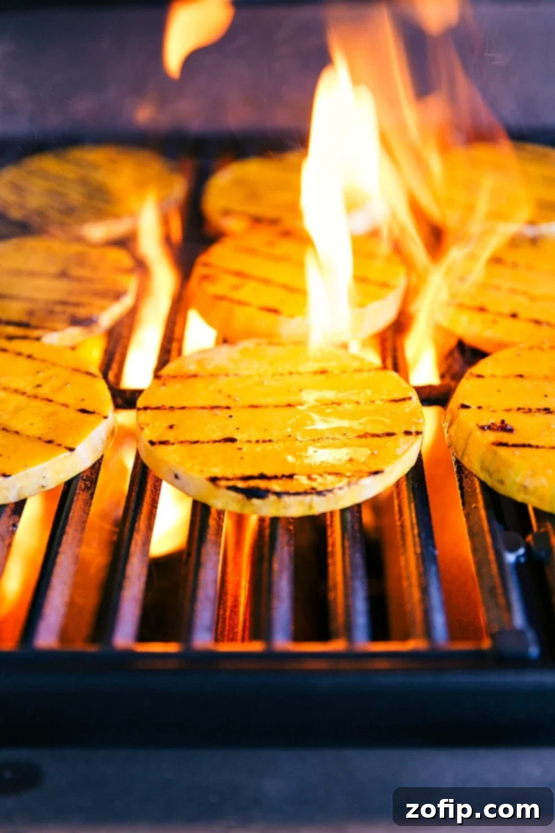 Image of the fire of the grill coming up on the butternut squash slices, showcasing the grilling process.