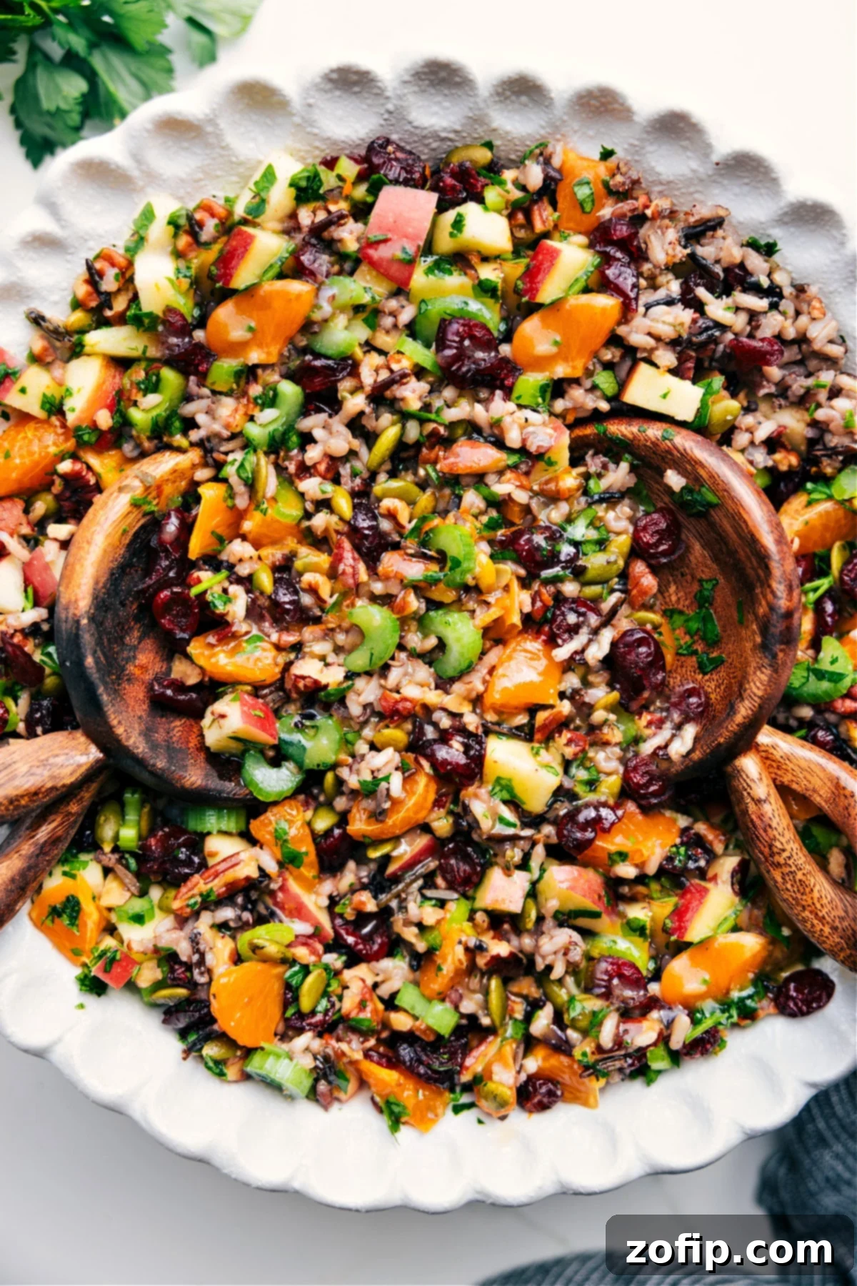 Big Bowl Of Wild Rice Pilaf: The Perfect Thanksgiving Side A large bowl of Cranberry Orange Wild Rice Pilaf, beautifully tossed with vibrant cranberries, orange segments, and green parsley, ready to serve.