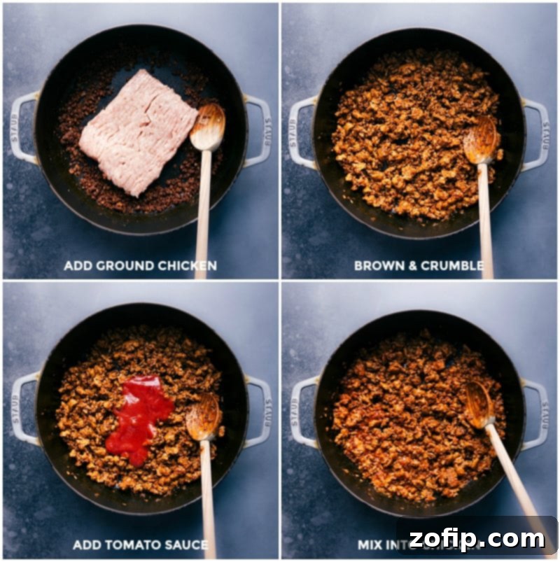 Ground chicken browning in a large cast-iron pan, alongside sautéed onions and garlic. Tomato sauce is being stirred into the meat, creating a rich and savory taco filling.