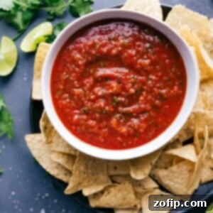 A big bowl of delicious salsa, packed with vibrant flavors, paired with a pile of crispy chips ready for dipping.