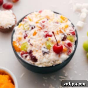 Heavenly Ambrosia Salad 2 A close-up of the delicious Ambrosia Salad in a serving bowl, garnished with a cherry.