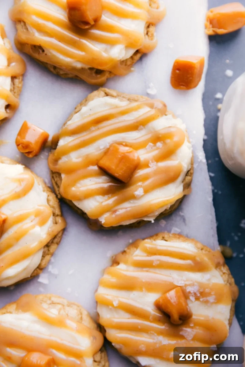 A beautiful stack of soft, frosted Salted Caramel Cookies, glistening with caramel drizzle and a sprinkle of sea salt.