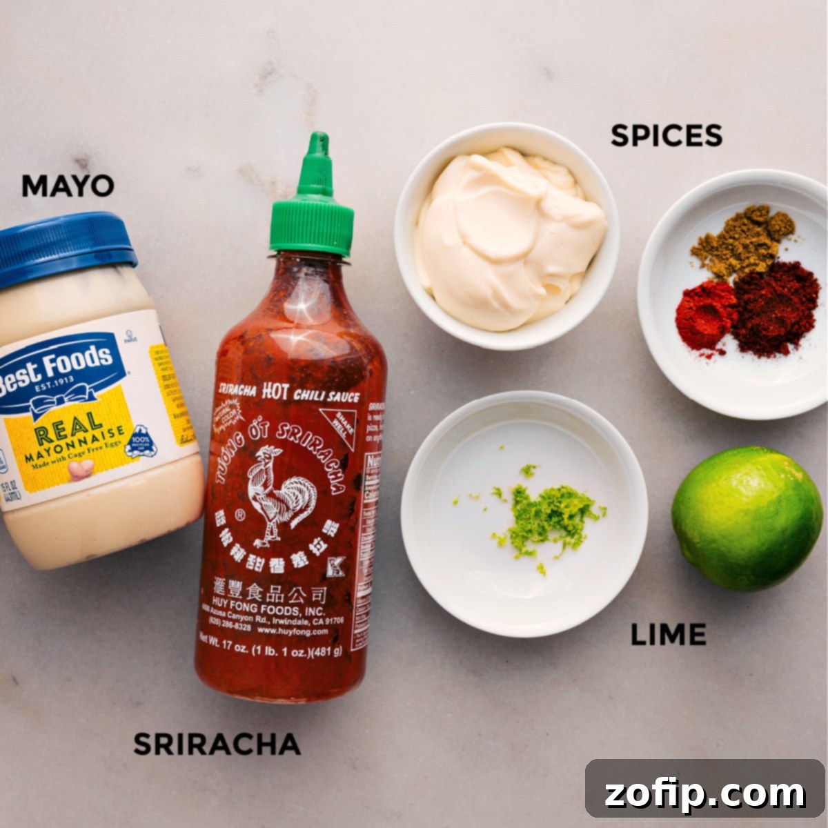 The sauce ingredients are prepped and ready to go, including creamy mayo, vibrant limes, a blend of spices like chili powder, cumin, and paprika, and a bottle of hot sauce.