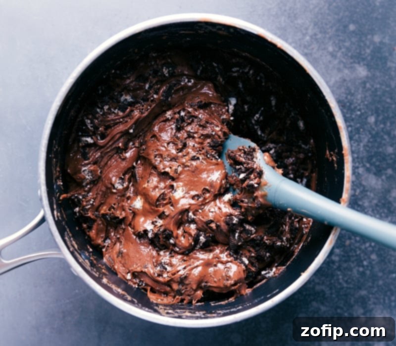 An overhead view of the smooth, melted fudge mixture, perfectly blended and ready to be transferred to a pan for setting, with a spatula visible.