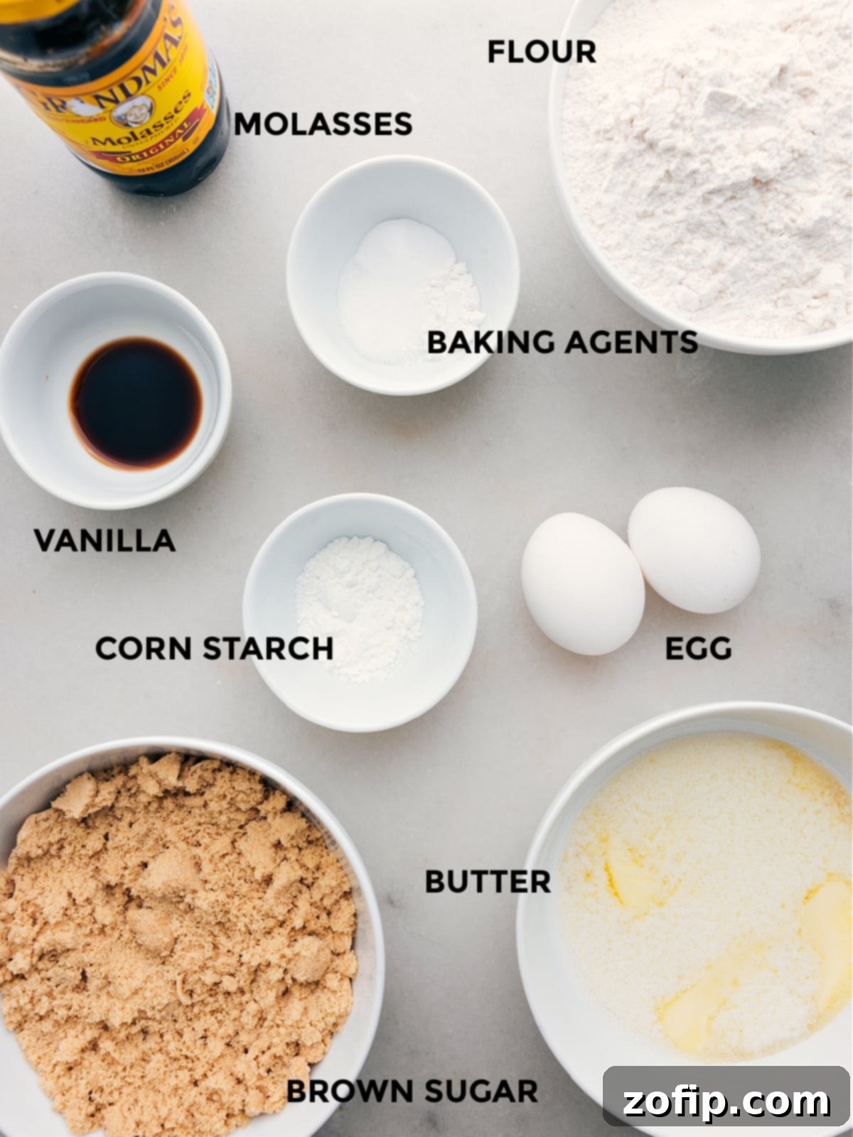 All the essential ingredients for brown sugar cookies, including butter, brown sugar, eggs, molasses, vanilla, flour, cornstarch, baking soda, baking powder, and salt, neatly laid out and ready for mixing.