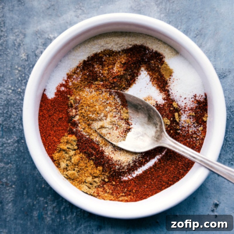 An inviting assortment of spices for homemade fajita seasoning, including vibrant ground chili powder, rich paprika, and earthy ground cumin.