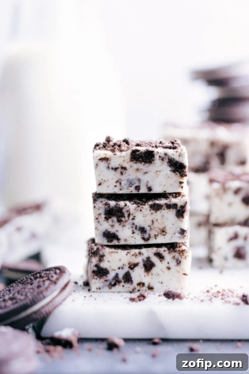 A stack of perfectly cut Oreo Fudge pieces, showcasing the creamy texture and embedded cookie bits.