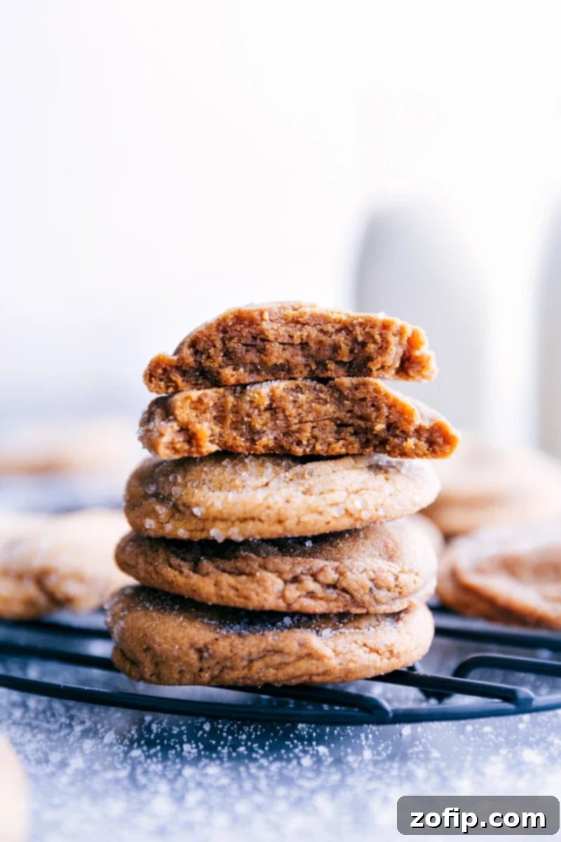 A plate of perfectly baked Gingersnap Cookies stacked up, showcasing their crackled tops and inviting color.