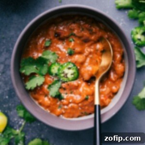Easy Slow Cooker And Instant Pot Pinto Beans 3 A bowl of freshly made crockpot pinto beans, garnished with fresh cilantro.