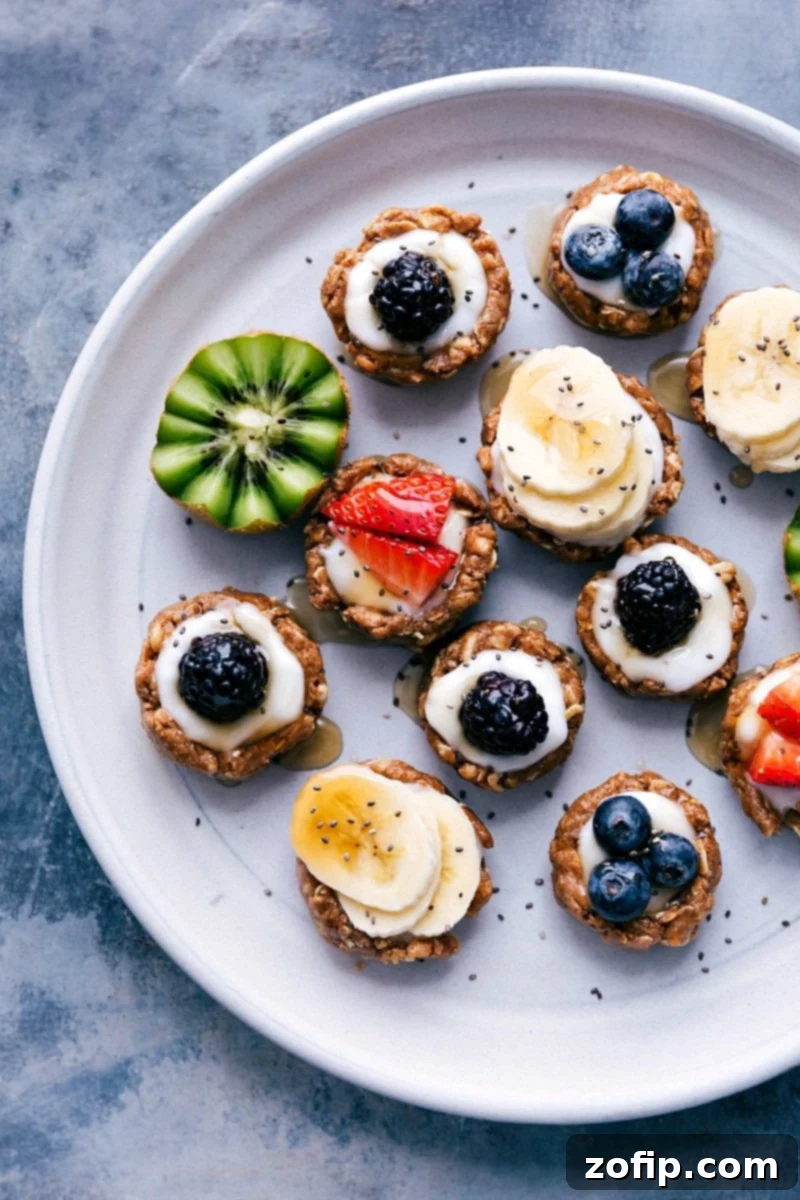 Beautifully arranged healthy no-bake fruit tarts on a serving tray, topped with a colorful assortment of fresh berries and fruit slices.